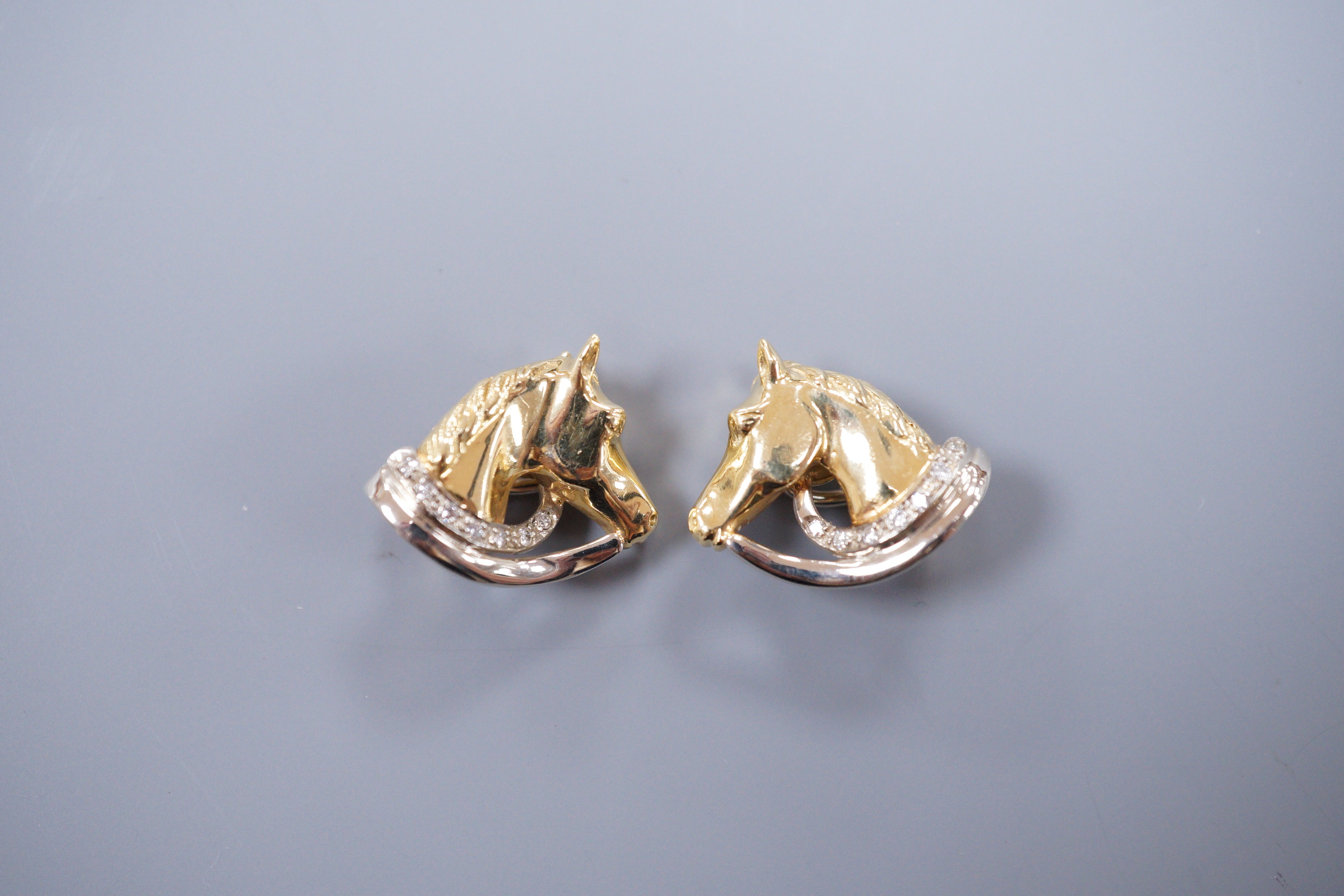 A pair of diamond set 18ct gold horse head ear clips, 2cm, gross 9.8 grams